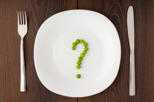 Question mark made of peas on plate